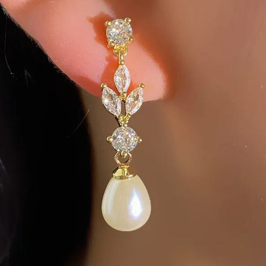 These elegant Fashion Marquise Cut Cubic Zircon Earrings feature simulated pearl and leaf-style marquise dangle, making them perfect for a special occasion. With a brilliant cubic zirconia design, these earrings combine classic elegance with modern glamour and are sure to be a favorite accessory